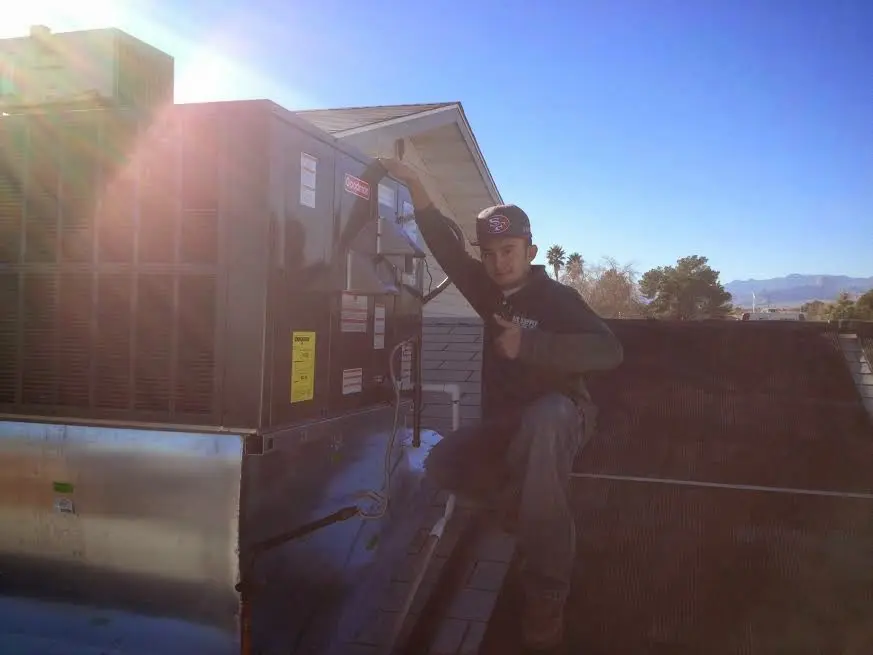 HVAC technician performing AC Tune-Up on a rooftop unit in Cooper